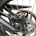 Rear motorcycle disc brake caliper and rotor with chain and swingarm detail