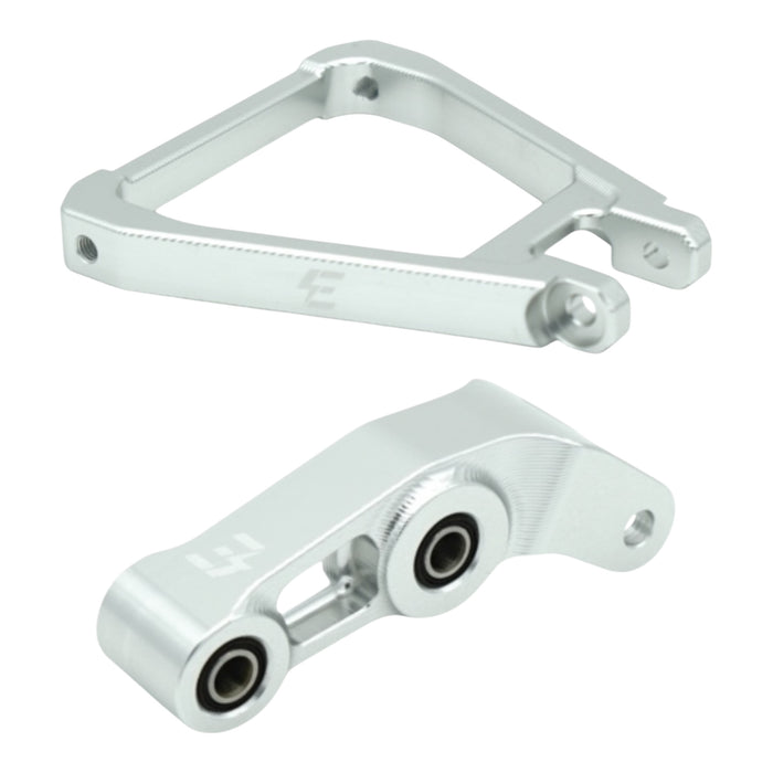 Silver aluminum motorcycle suspension linkage parts with bearings on white background