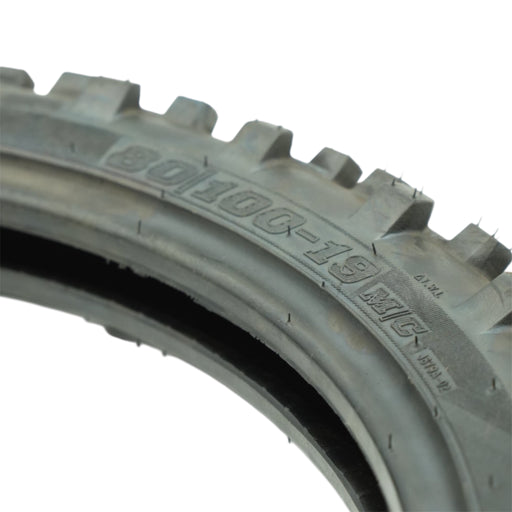 Knobby off-road tire close-up showing tread and sidewall markings