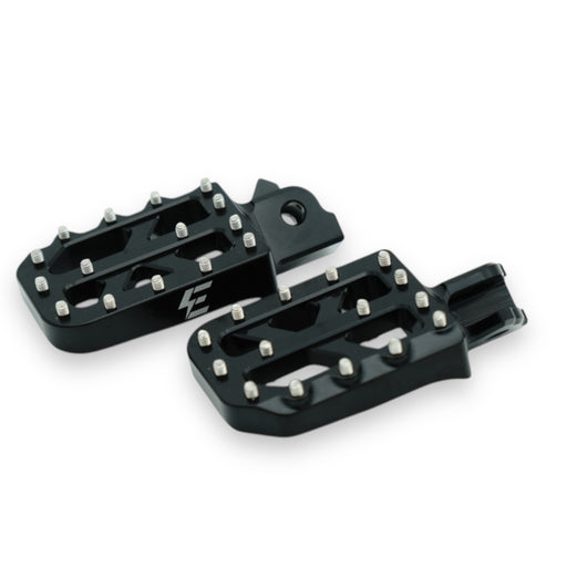 Pair of black metal motorcycle foot pegs with silver grip pins and logo