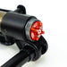 Close-up of a black and red adjustable shock absorber component on white background.