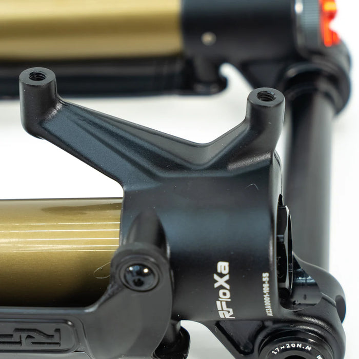Close-up of black and gold suspension fork part with "Reptile FloXa" logo.