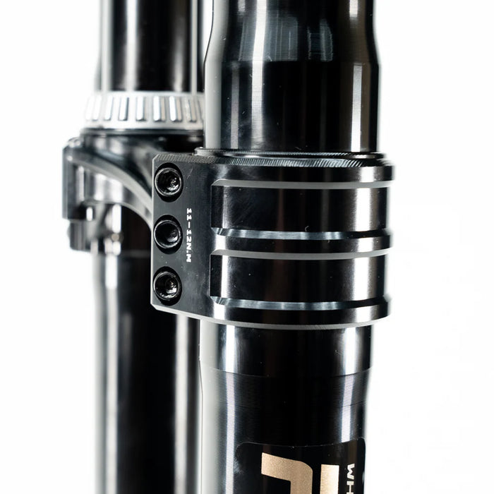 Close-up of a black metal clamp with screws on a cylindrical tube, industrial design.