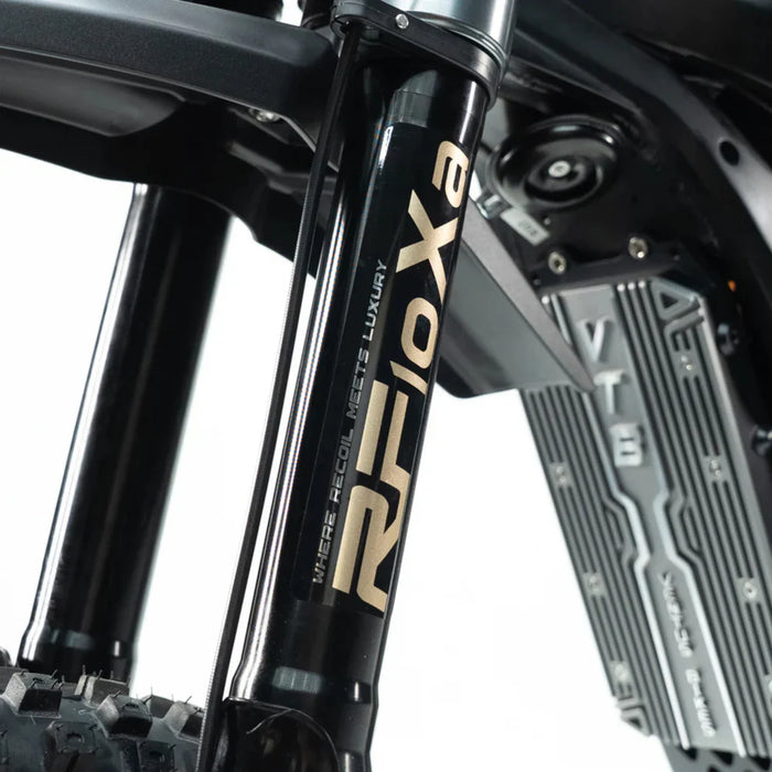 Close-up of black motorcycle fork leg with "Rifoxa" decal and radiator fins visible